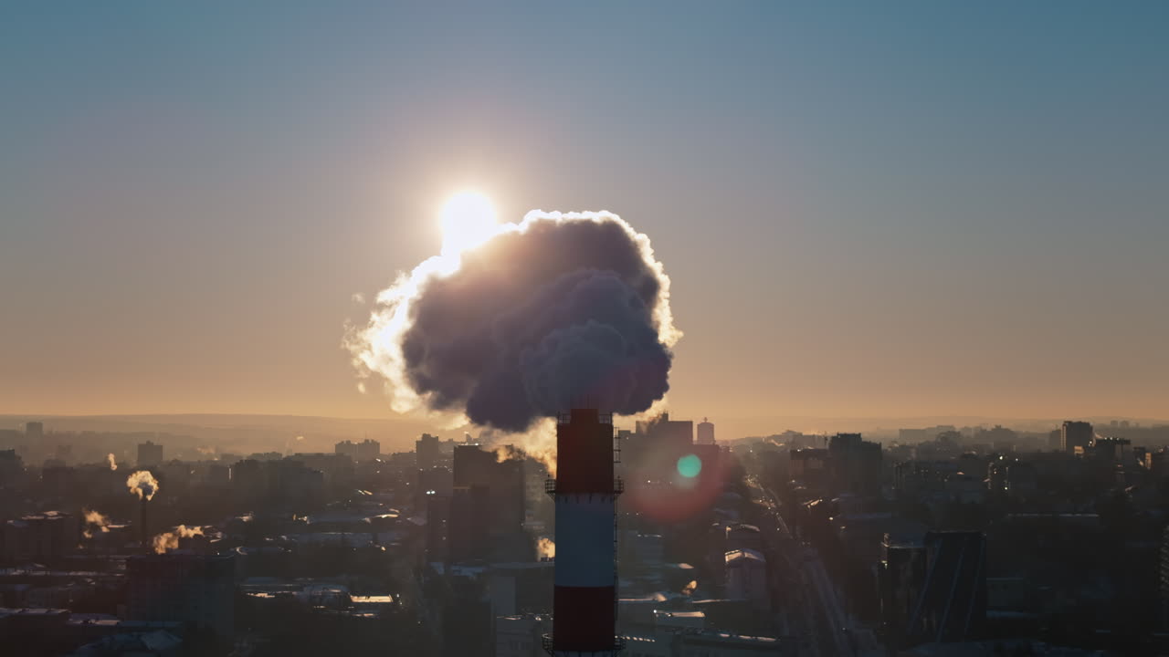 Aerial drone view of a working thermal power station in Chisinau at sunset. Steam and smoke coming from pipes. Moldova