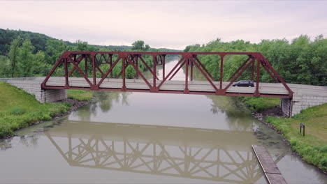 Drohnenclip-Absteigend,-Der-Eine-Stahlbrücke-Zeigt,-über-Die-Ein-Auto-Fährt