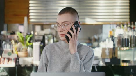 woman talking on phone in a cafe