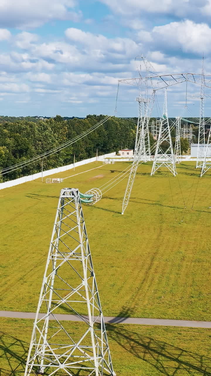Aerial view of electric high voltage construction. Electrical power distribution system. Vertical video