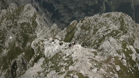 drone shot of top of moutanin rombon, birdseye perspective, group of hikers climbing up the mountain