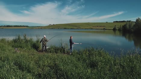 Two-young-guys-are-fishing-on-lake