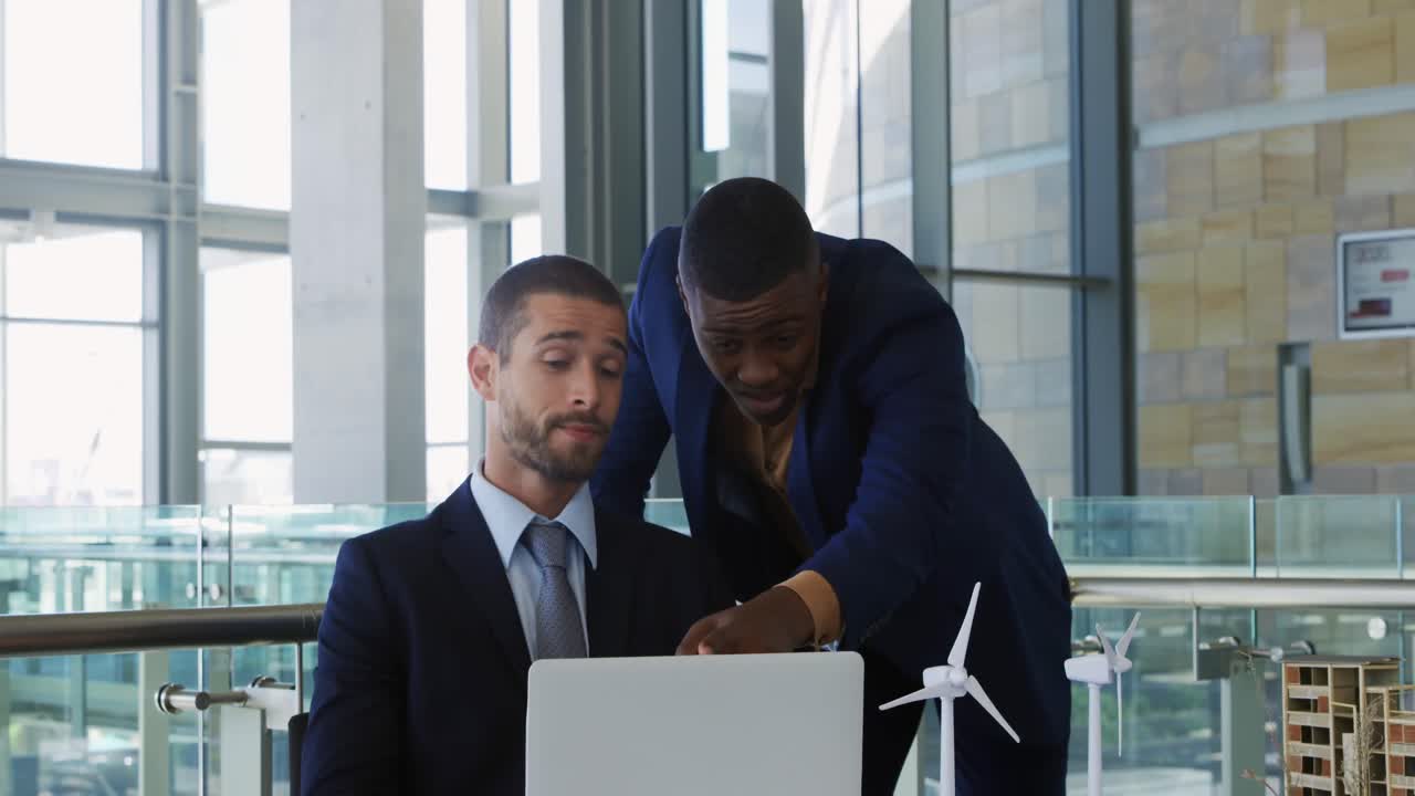 Giovani uomini d'affari che utilizzano un laptop in un ufficio moderno