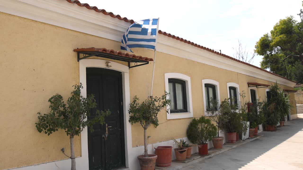un edificio en atenas con bandera griega