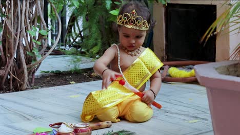 Entzückendes-Kleinkind,-Gekleidet-Als-Hinduistischer-Gott-Krishna,-Süßer-Gesichtsausdruck-Mit-Flöte-Bei-Janmashtami