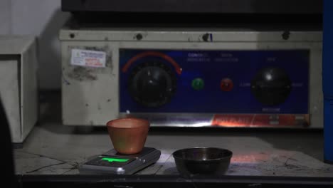 primer concepto de seguridad, copa de vidrio con muestra de suelo está a mano en guante de goma en el laboratorio químico de primer plano, análisis bioquímico del concepto de suelos
