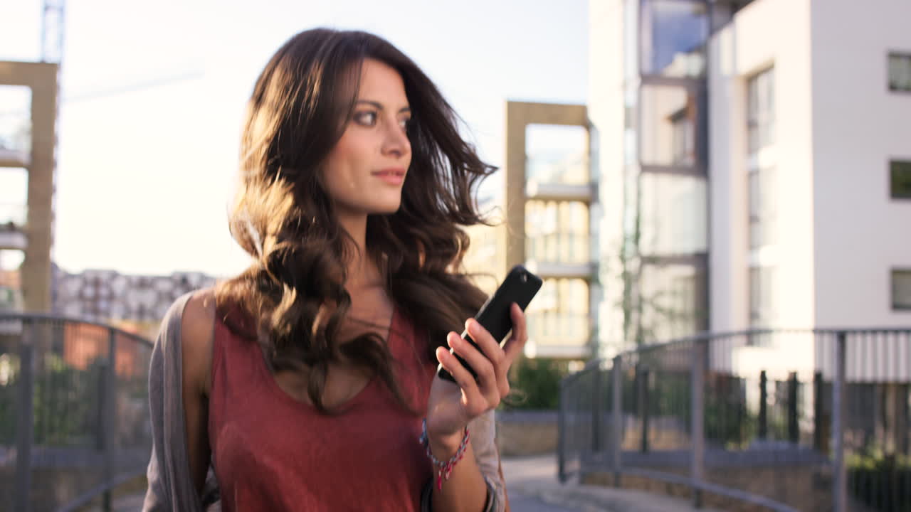 una mujer usando su teléfono celular mientras camina afuera