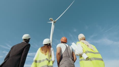 equipo de ingenieros inspeccionando una turbina eólica
