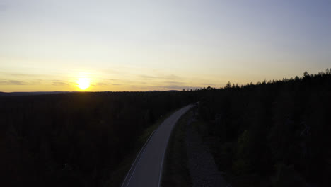 empty road in the middle of forest during sunrise