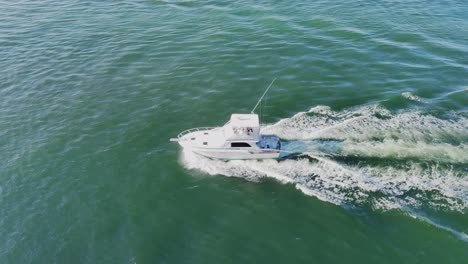 a small fishing boat moving fast in middle of the ocean aerial view | drone shot of a small fishing boat moving in middle of the ea video background in 4k