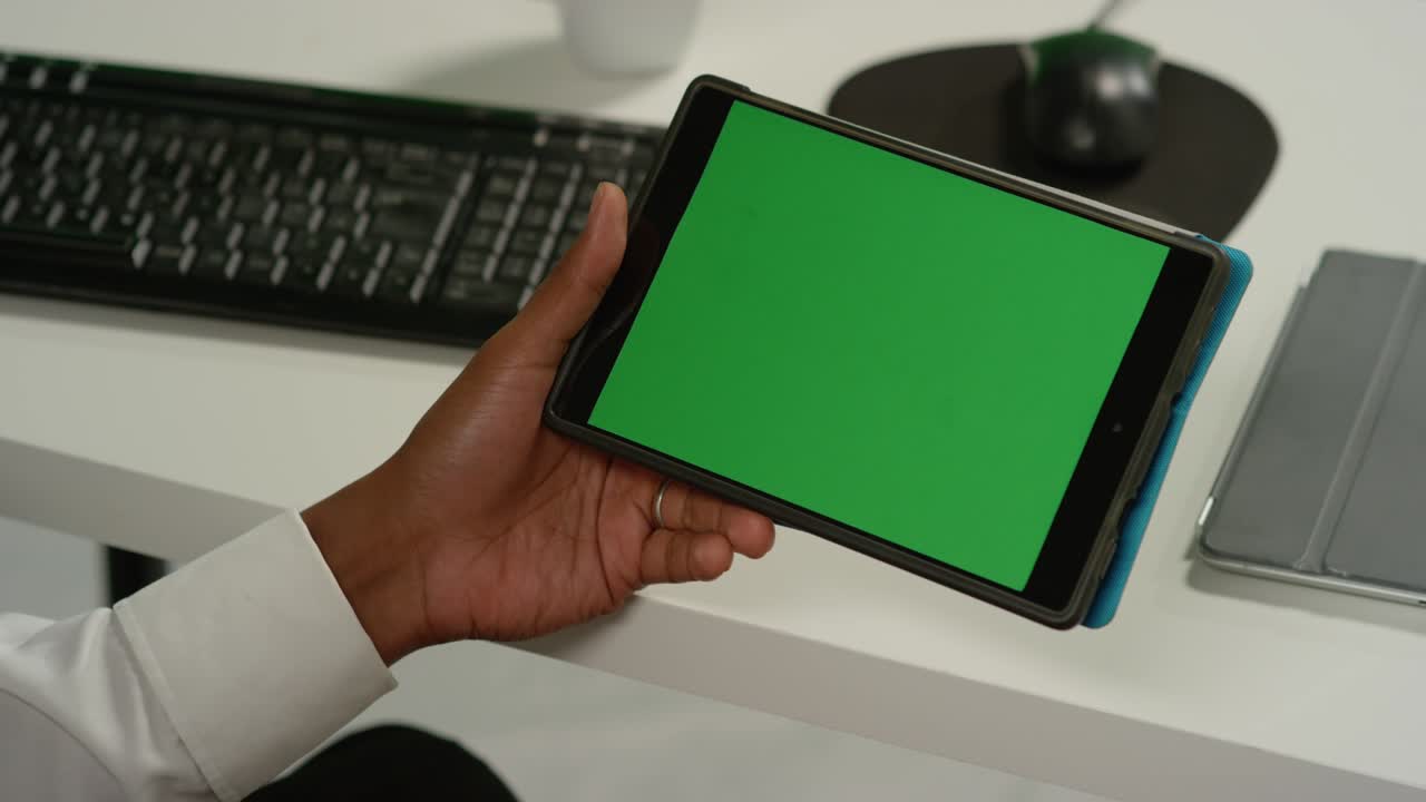 CU Man at Desk Holding Tablet with Green Screen