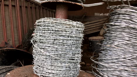 pan from left to right of a spool of barbed wire in an old barn.