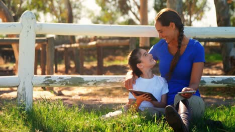 Mother-and-daughter-using-digital-tablet-and-mobile-phone-in-ranch-4k