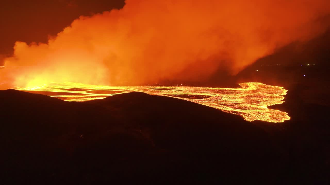 Grande pennacchio di fumo illuminato da lava incandescente nella penisola di Reykjanes, ripresa aerea.