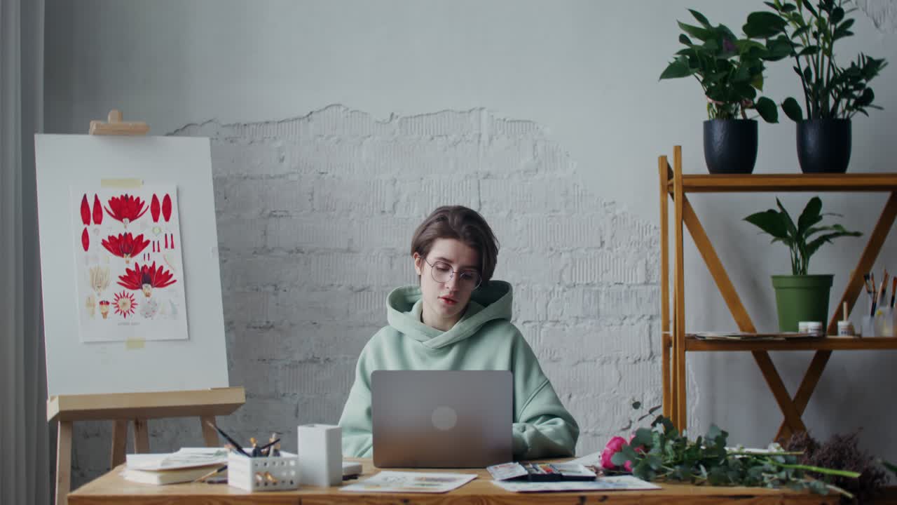 예술 스튜디오에서 노트북을 사용하는 젊은 여성