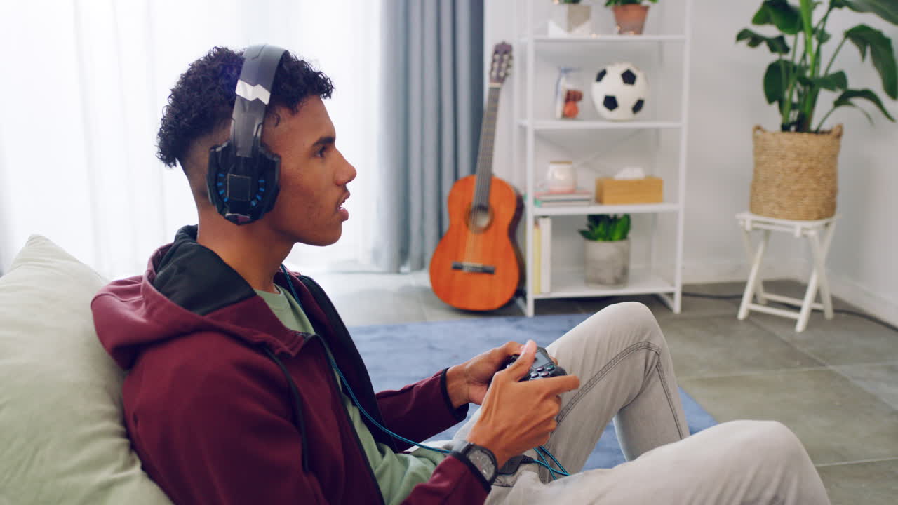 An excited gamer is sitting on a couch