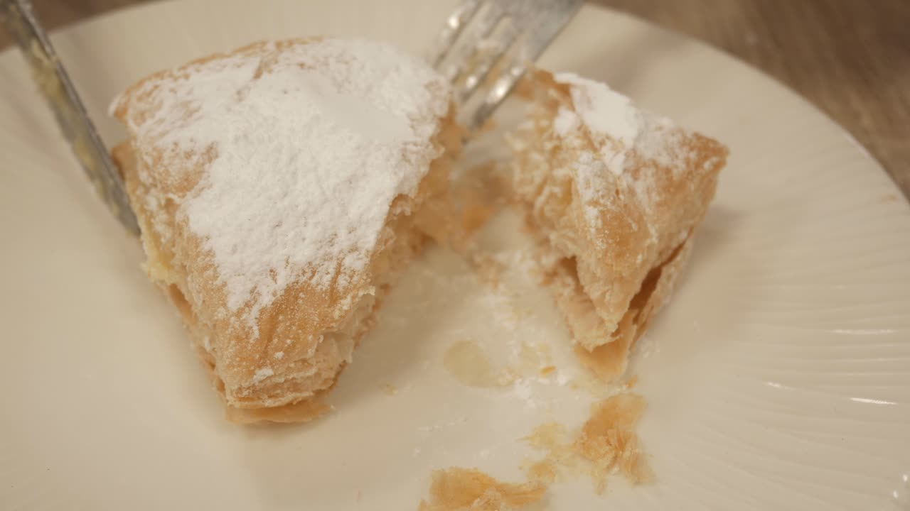 Slicing a sweet, layered Miguelito dessert from La Roda, Spain