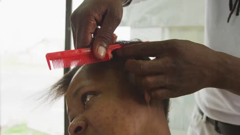 hombre africano dividiendo el cabello de la mujer africana