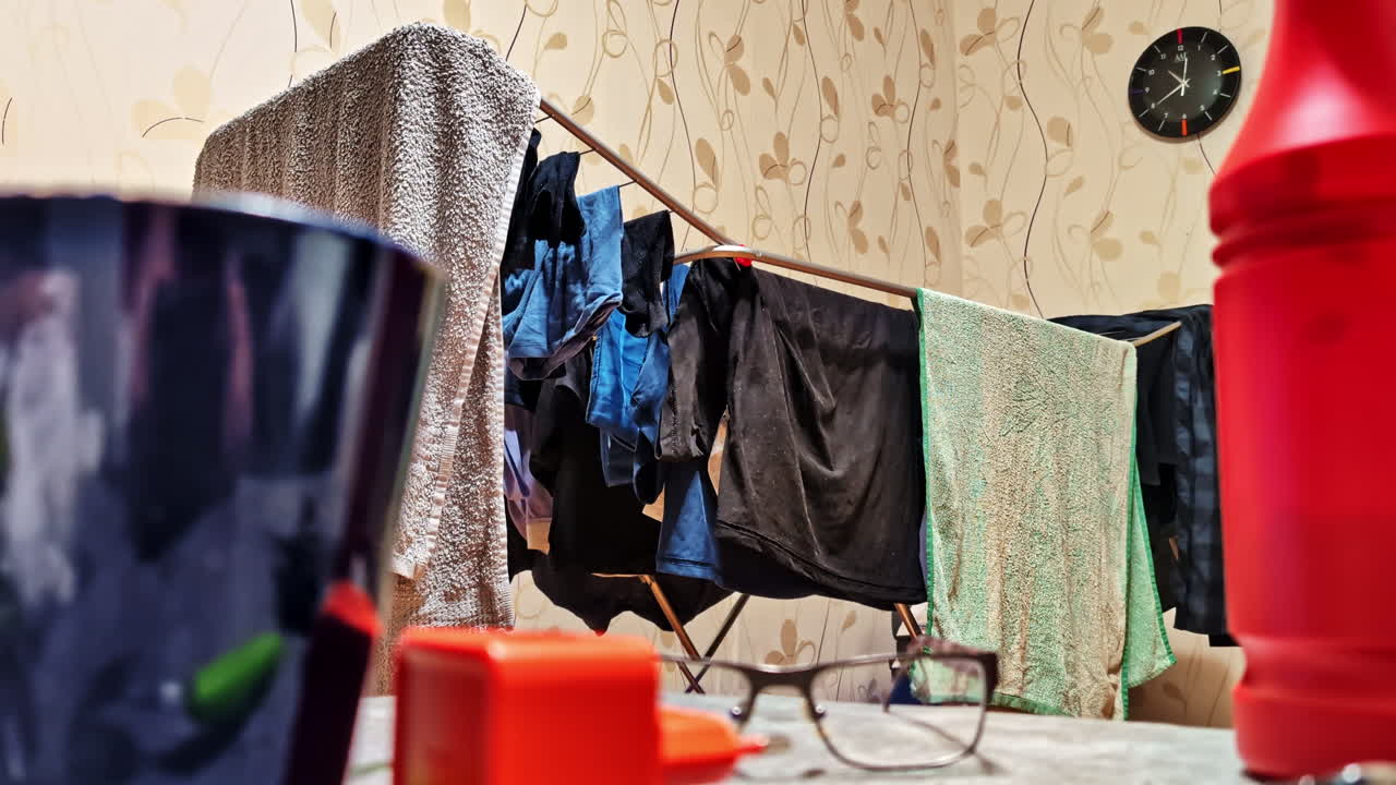 Clothes drying in bachelor apartment with scattered items and lived-in interior