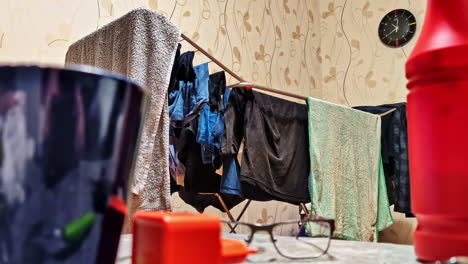 clothes drying in bachelor apartment with scattered items and lived-in interior