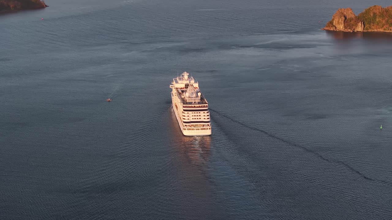 Aerial View of Cruise Ship Sailing On Coron Island At Sunset In Palawan, Philippines. tilt-up, rear shot