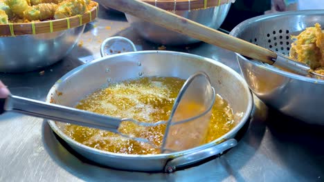 cocinando un bocadillo de arroz frito en el puesto de mercado flotante de bangkok