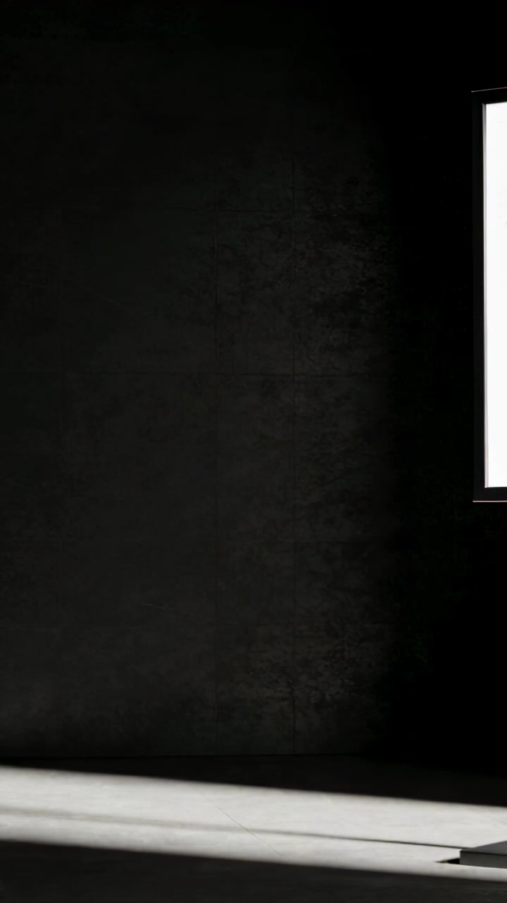 Vertical video: Opening shot showing dark wall centered in dim room with lit screen and white ledge