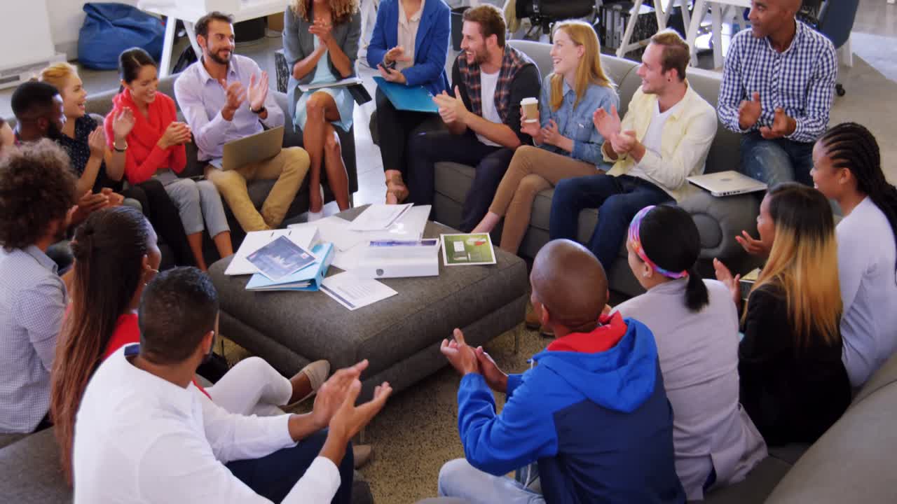 Group of business executives applauding during meeting