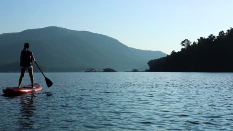 person paddleboarding on a tranquil mountain lake