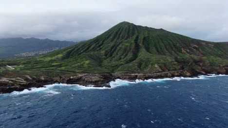 drone flying above stormy sea toward koko head on a gloomy day in hawaii