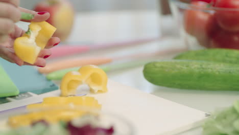 Woman-hands-peeling-yellow-peppers-in-kitchen-table-in-slow-motion.