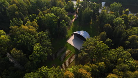 top down aerial over forest canopy and small home near pavilosta, latvia