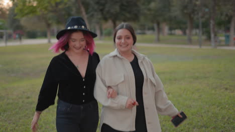 two women friends walking in a park