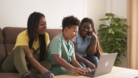 family using laptop together on couch