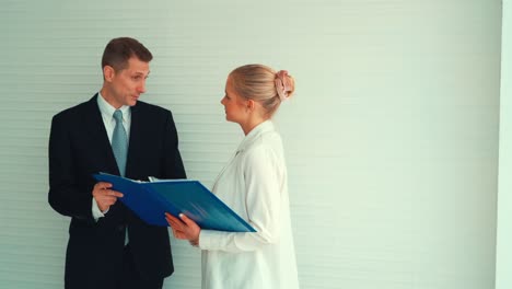 Two-business-people-talk-project-strategy-at-office