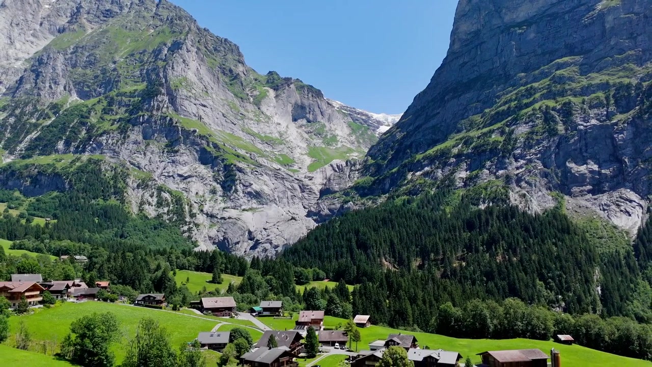 Elokuvamainen taaksepäin lentävä dronekuva, joka esittelee majesteettista Wetterhorn-vuorta ja alppien Gutz-jäätikköä Grindelwaldin lähellä. Kaunis Sveitsin Alppien maisema aurinkoisena kesäpäivänä.