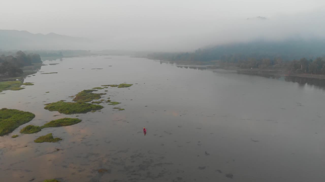 vista épica del paisaje aéreo del lago rodeado de montañas cubiertas de niebla