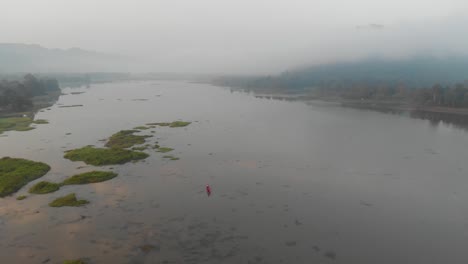 epic aerial landscape view of lake surrounded by mountains covered in fog