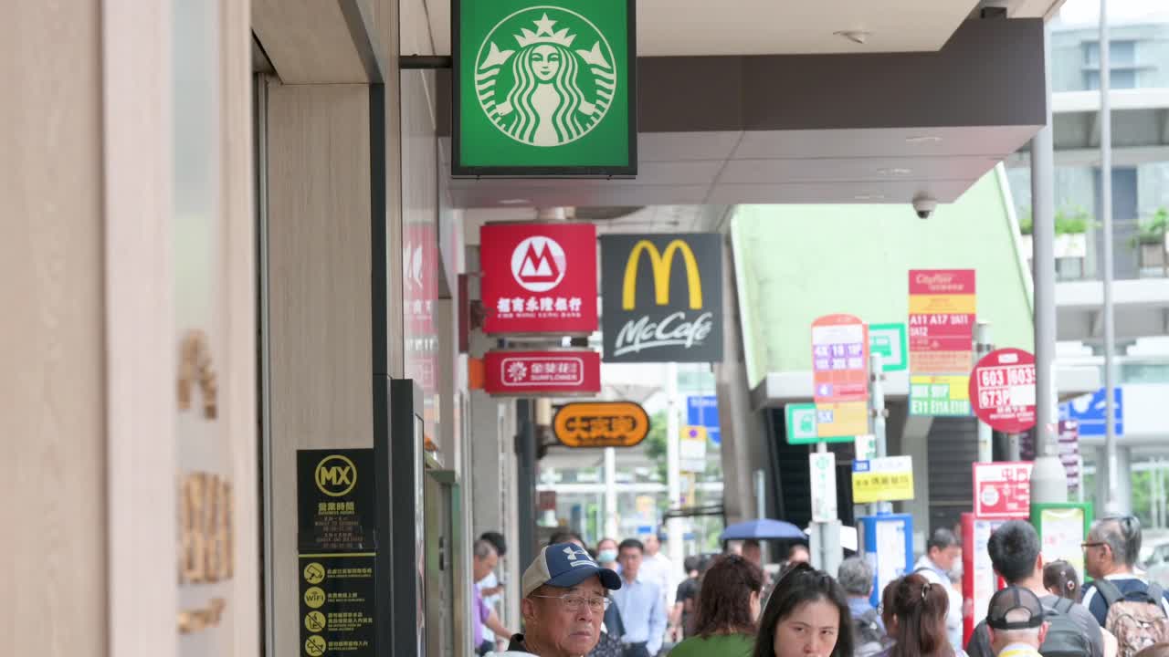 A street view of people walking past the American multinational companies Starbucks Coffee and McDonald's stores in Hong Kong, China.