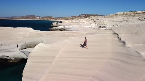 female tourist exploring sarakiniko beach, milos island, greece