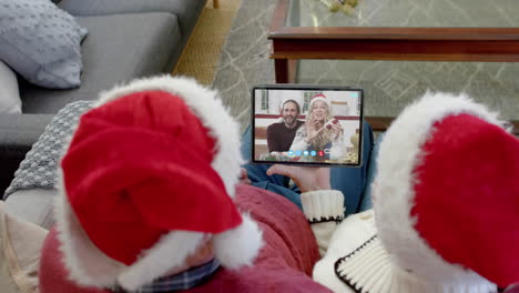 Two-happy-caucasian-couples-having-christmas-tablet-video-call,-slow-motion