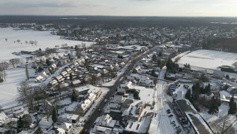 aerial of busy road running through small rural town in winter