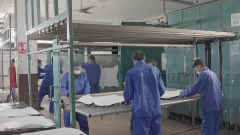 production workers in a leather factory processing animal hides for manufacturing.