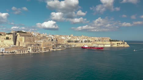 toma aérea sobre el agua hacia una ciudad vieja rodeada de mar y un puerto