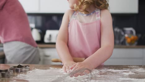 caucasian mother and daughter having fun cooking together