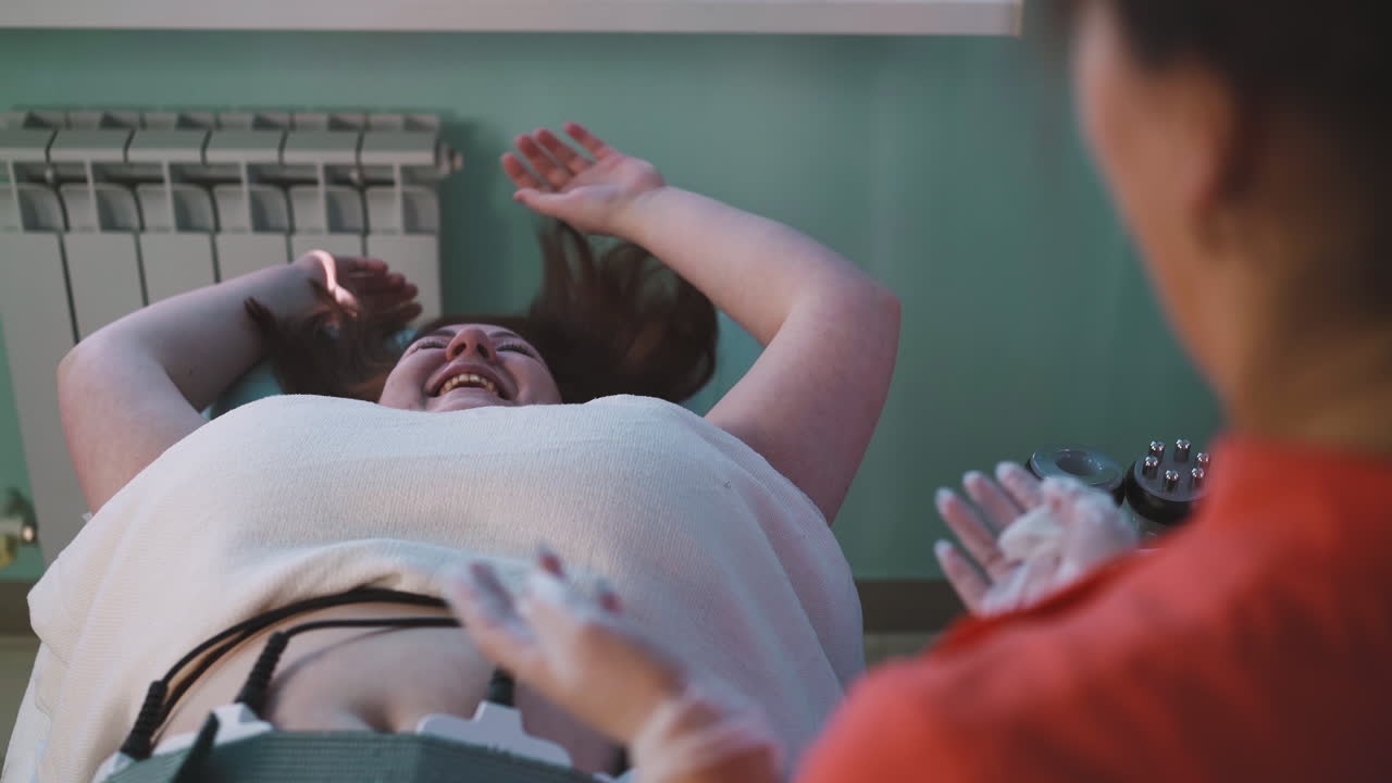 과체중인 여성이 전기적 근육 자극을 받습니다.