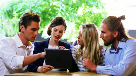 amigos discutiendo sobre una tableta digital