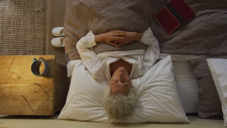 senior mixed race woman lying in bed sleeping