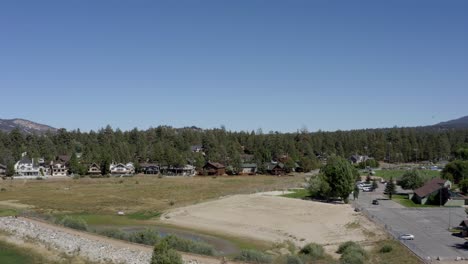 A-drone-shot-flying-towards-houses-ascending-over-the-trees-in-big-bear,-San-Bernardino-County,-California