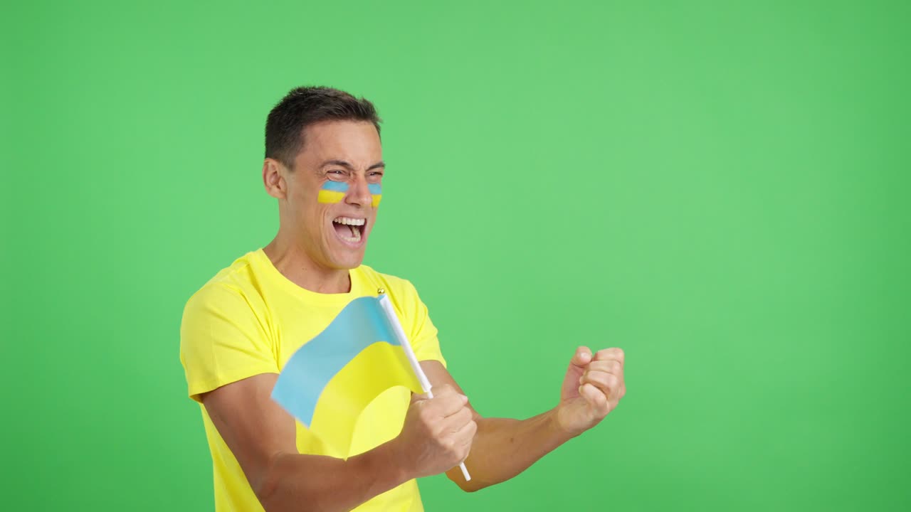 Ukrainian supporter screaming and waving a national flag looking away